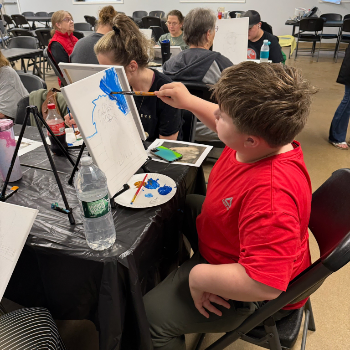 A child painting on a canvas.