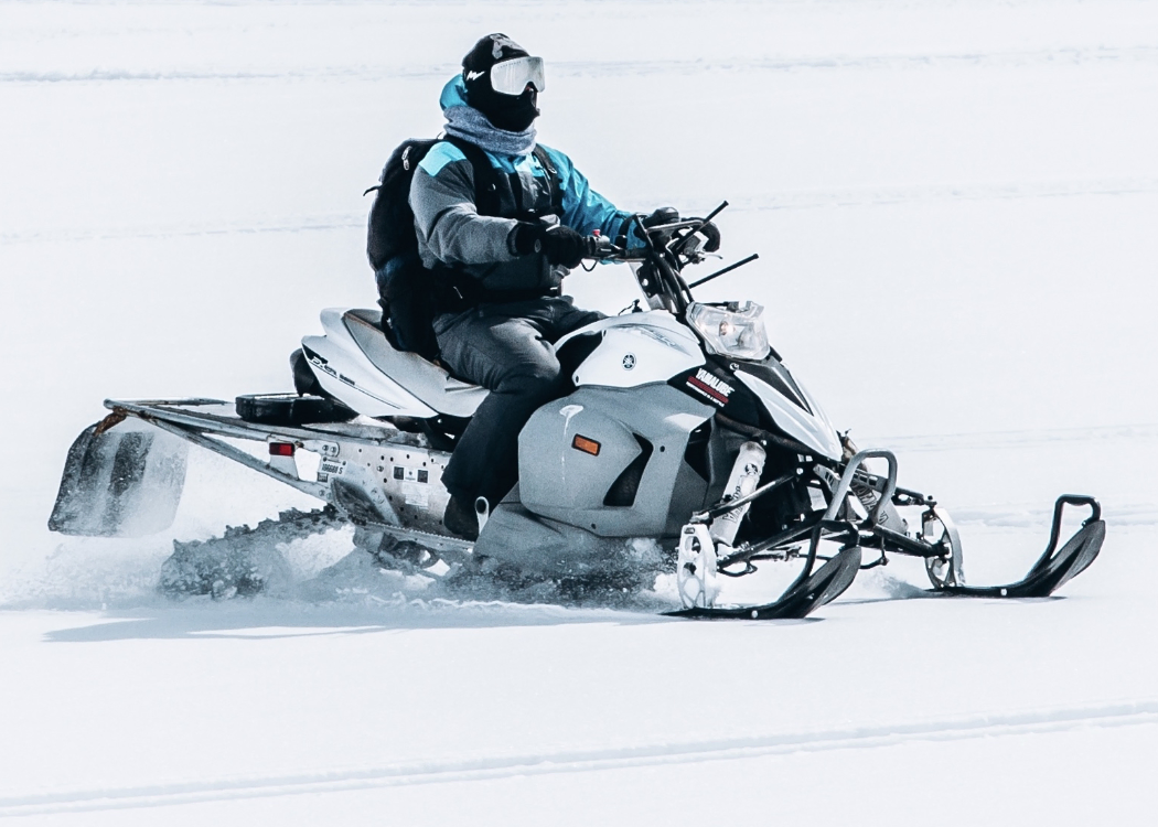 Gentleman riding a snowmobile.
