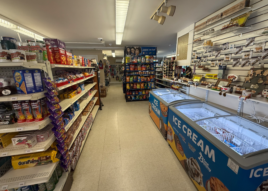 Store showing snacks on shelves and ice cream coolers.